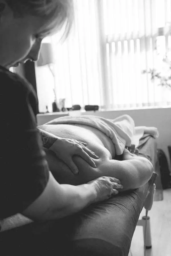 Imagen donde sale Klaudia realizando un masaje a una señora en el hombro